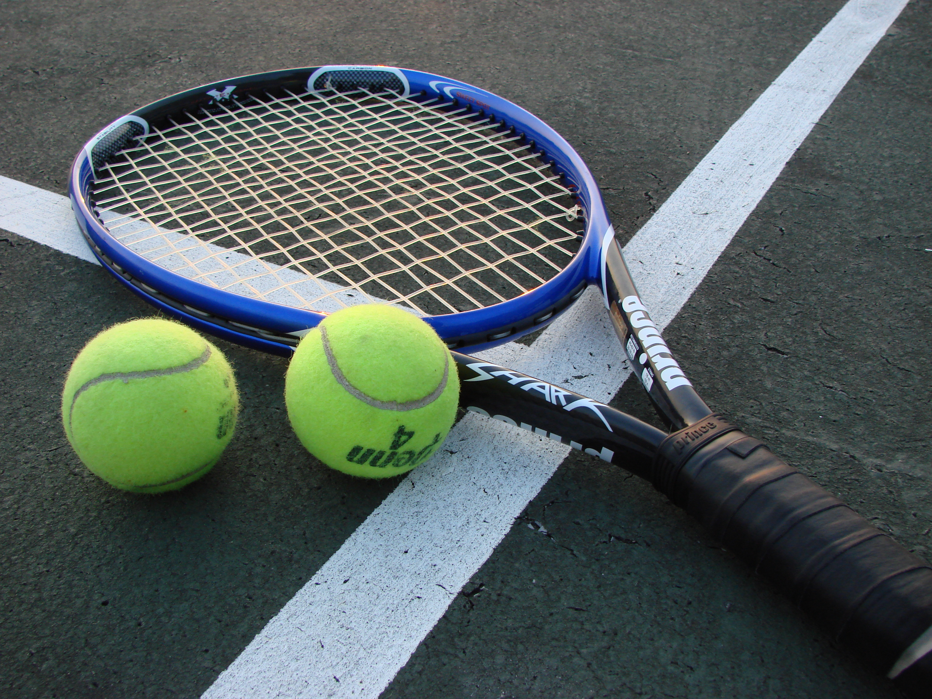 Racchetta e palline da tennis su un campo