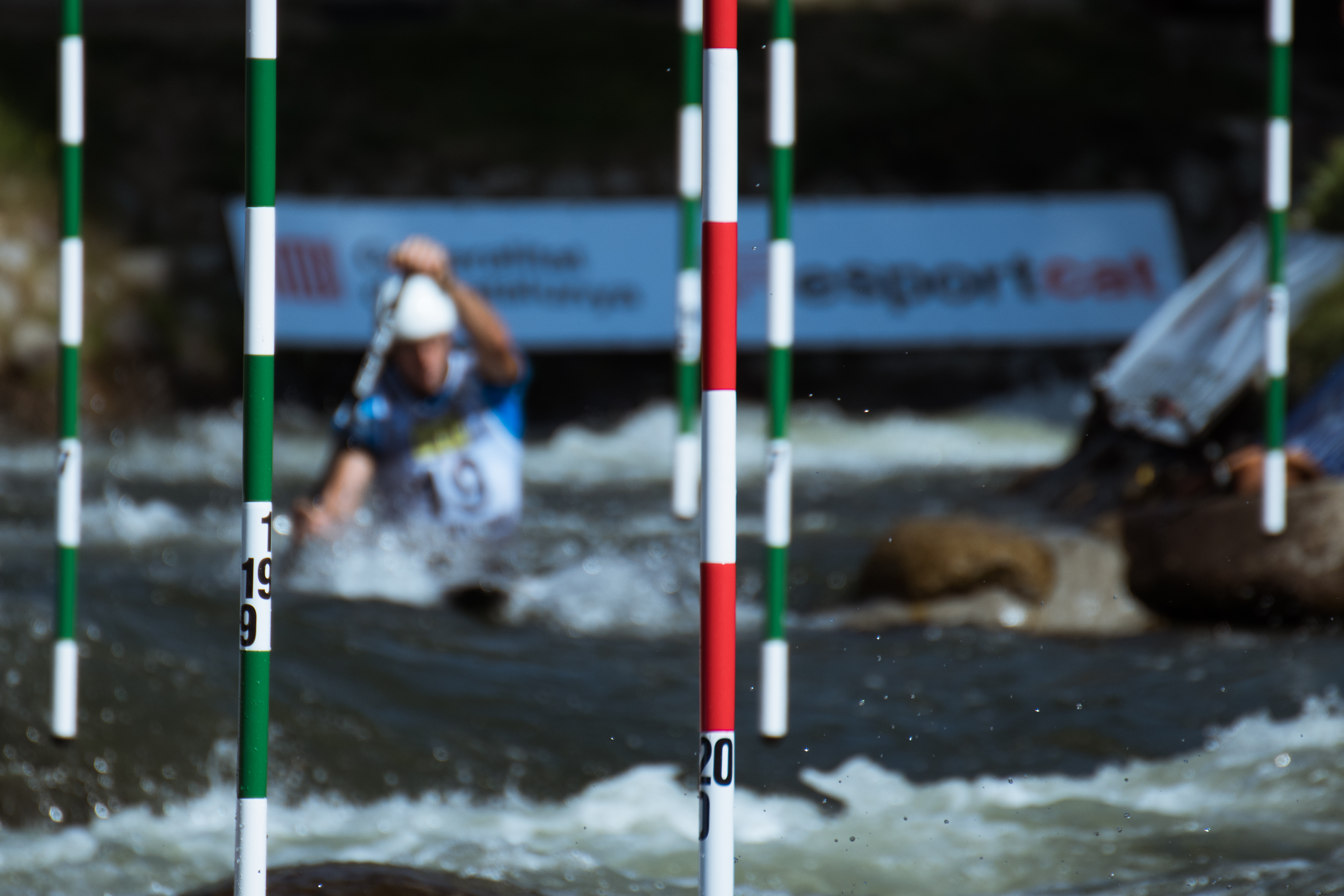 Atleta in lontananza tra le porte di canoa slalom